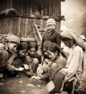 Kids playing with a spinning top. Chitkul, Himalayas.